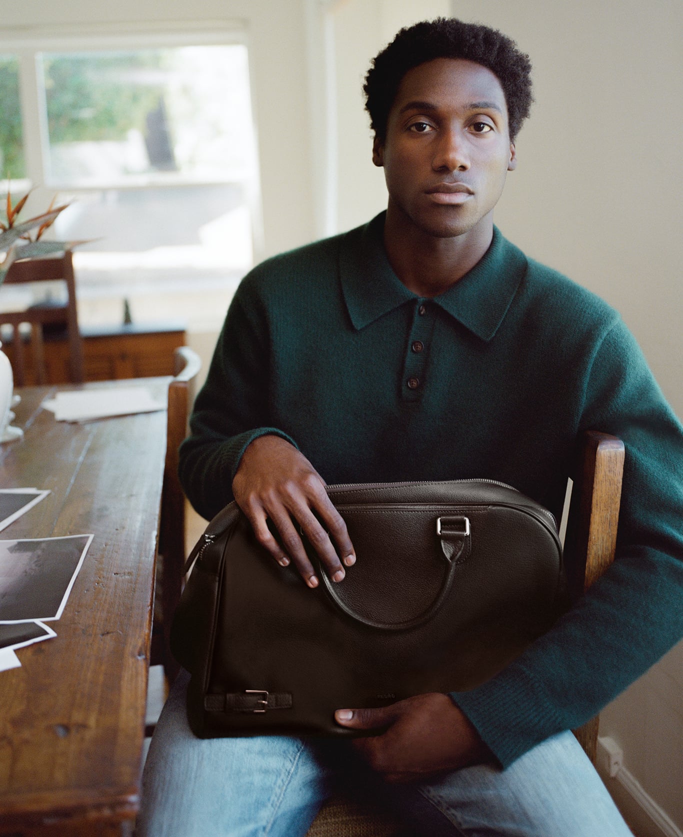Jabari Wimbley seated with a dark brown PEDRO bag on his lap