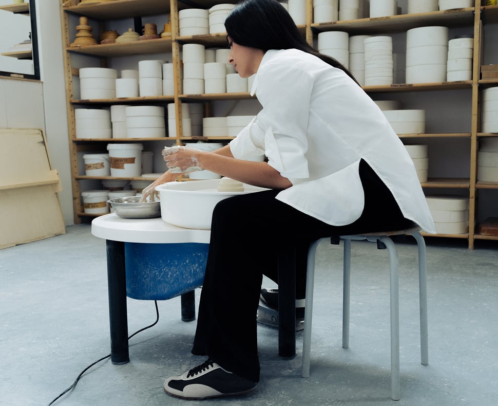 Tahni Bouhadana working at a pottery wheel in her studio